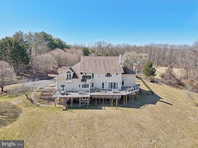 rear view of property with a deck and a yard