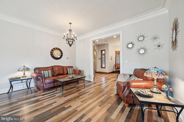 living room featuring visible vents, crown molding, baseboards, wood finished floors, and a notable chandelier