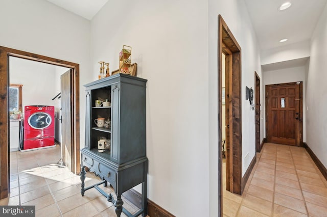 hallway with washer / clothes dryer, recessed lighting, baseboards, and light tile patterned floors