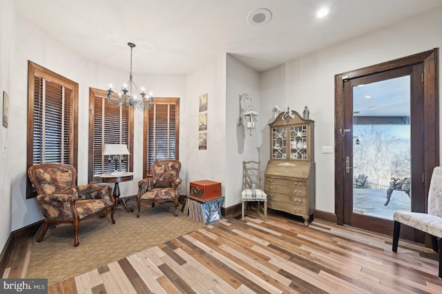 sitting room with recessed lighting, an inviting chandelier, baseboards, and light wood-style floors