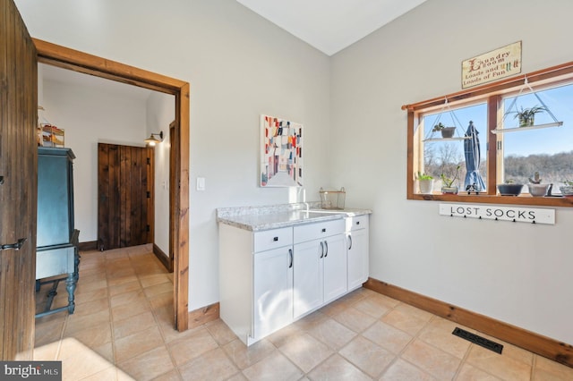 laundry area featuring light tile patterned flooring, baseboards, and visible vents