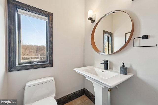 bathroom with tile patterned flooring, toilet, and baseboards