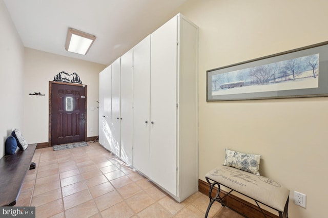 entryway with baseboards and light tile patterned flooring