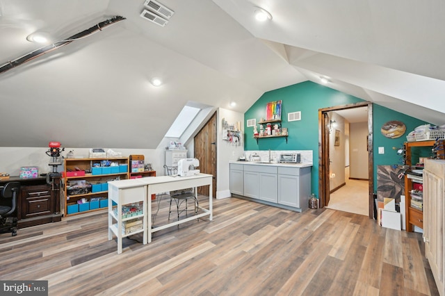 office area featuring visible vents, lofted ceiling, and wood finished floors