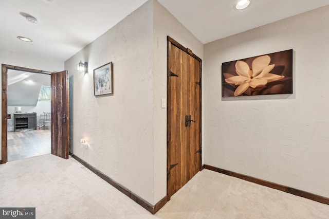 corridor featuring carpet flooring, recessed lighting, baseboards, and a textured wall