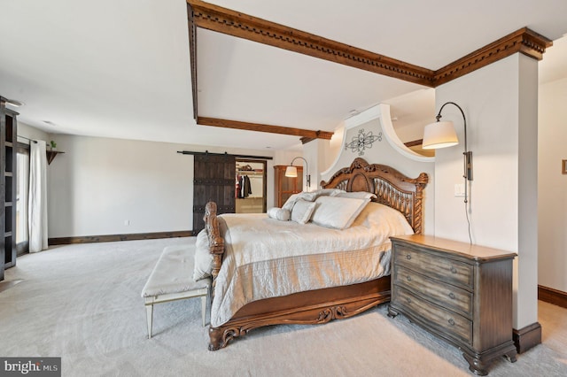 bedroom with a barn door, baseboards, and carpet