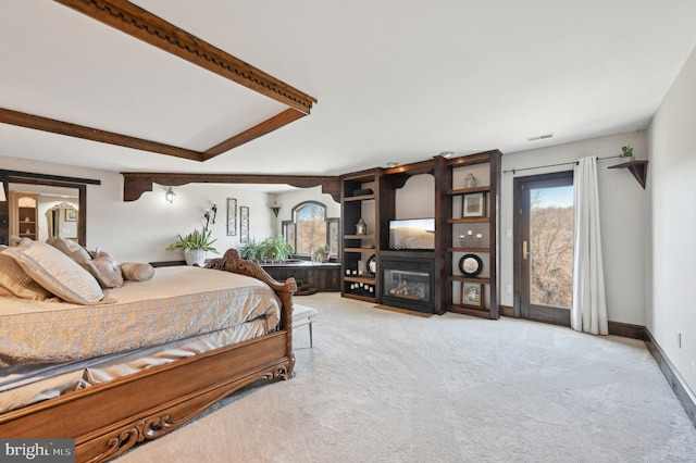 bedroom featuring beamed ceiling, a fireplace with flush hearth, carpet flooring, baseboards, and access to exterior