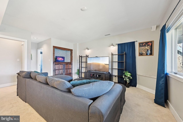 living area with visible vents, baseboards, and light carpet