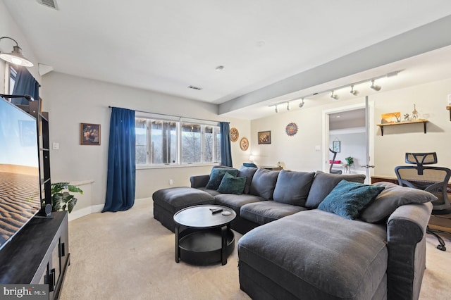 living area with visible vents, baseboards, light colored carpet, and track lighting