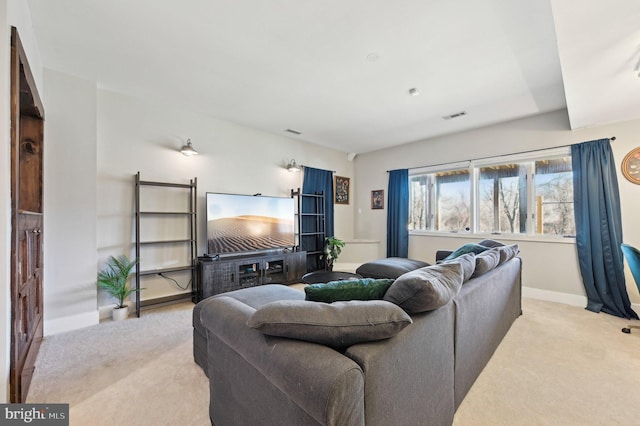 living area with baseboards, visible vents, and light carpet