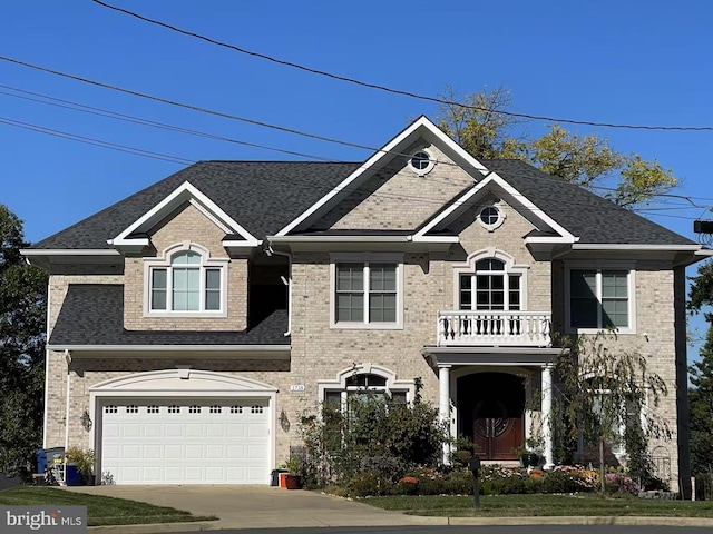 colonial house with concrete driveway, brick siding, roof with shingles, and a balcony