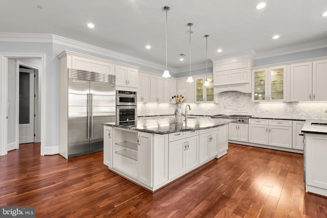 kitchen featuring appliances with stainless steel finishes, a center island with sink, dark wood-style floors, and ornamental molding