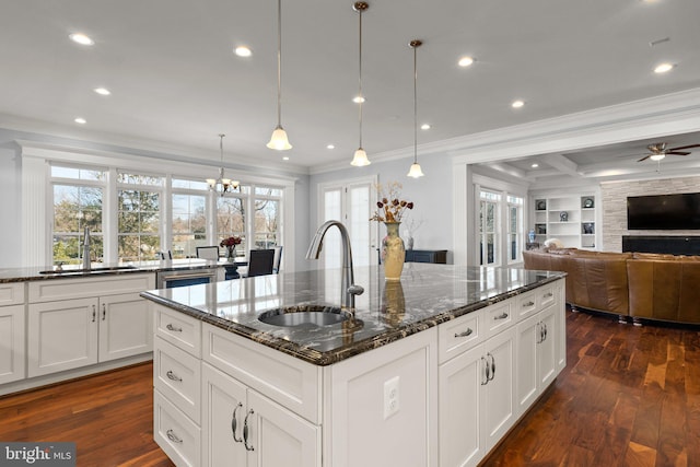 kitchen featuring crown molding, dark wood finished floors, open floor plan, and a sink