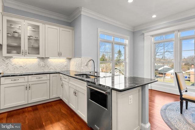 kitchen with tasteful backsplash, dark wood finished floors, a peninsula, crown molding, and a sink