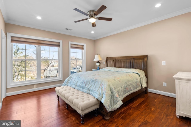 bedroom featuring dark wood-type flooring, visible vents, crown molding, and baseboards