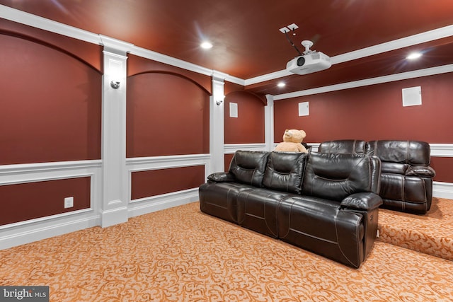 carpeted home theater featuring ornamental molding, recessed lighting, wainscoting, and a decorative wall