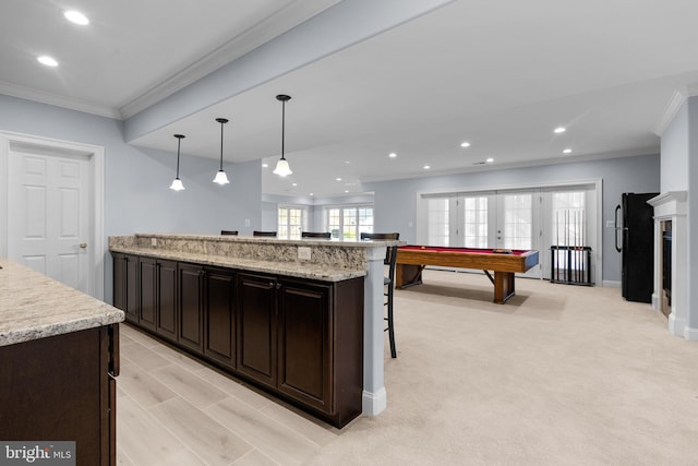 kitchen featuring recessed lighting, a breakfast bar area, ornamental molding, and freestanding refrigerator