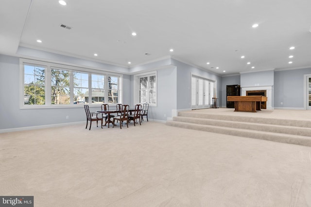 dining space with baseboards, light colored carpet, ornamental molding, a fireplace, and recessed lighting