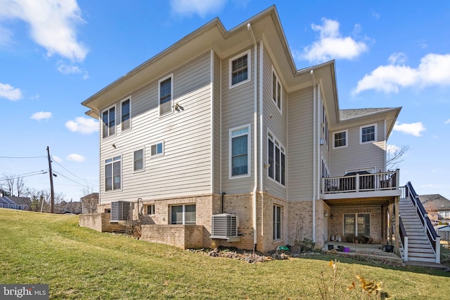 view of home's exterior with a lawn, stairway, a deck, central AC, and brick siding