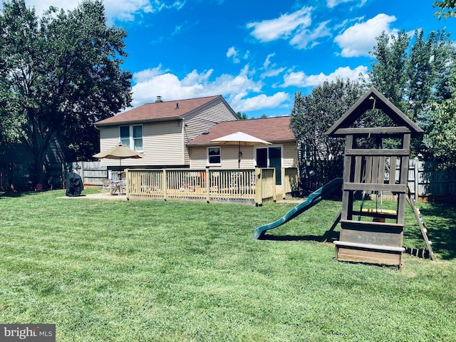 view of playground with a yard, fence, and a patio