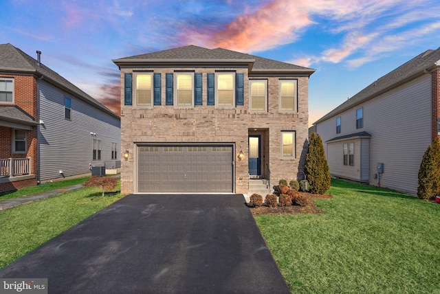 view of front facade with aphalt driveway, brick siding, a yard, central AC, and a garage