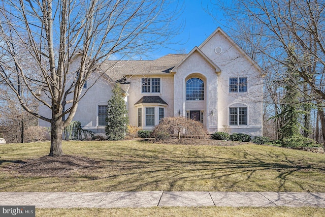 view of front facade with a front lawn and stucco siding