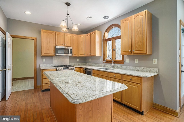 kitchen with a sink, light wood-type flooring, visible vents, and stainless steel appliances