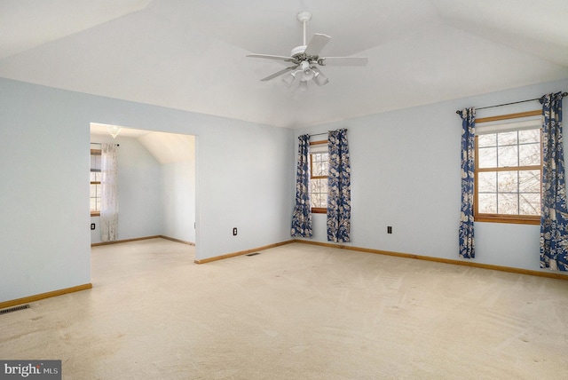 unfurnished room featuring vaulted ceiling, carpet flooring, a ceiling fan, and plenty of natural light