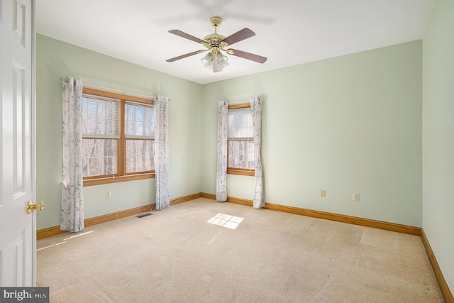 spare room with visible vents, baseboards, a ceiling fan, and carpet floors