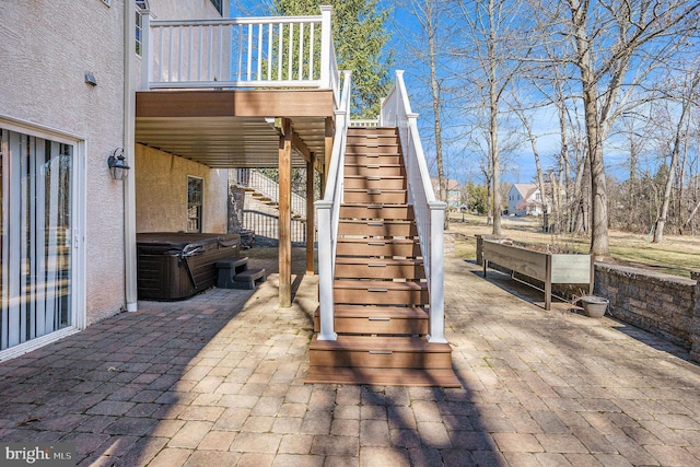 view of patio / terrace with stairs and a hot tub