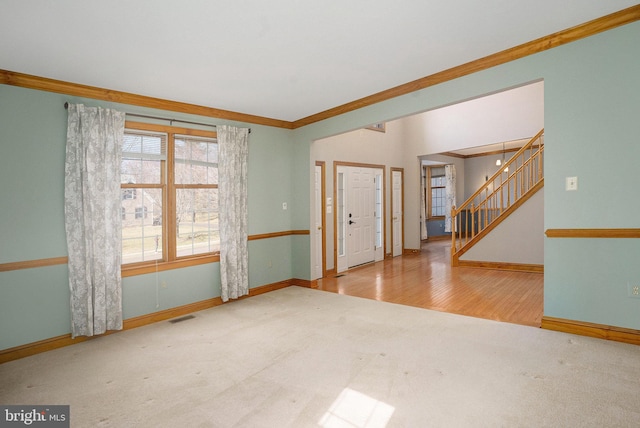 entryway with stairway, carpet, baseboards, visible vents, and ornamental molding