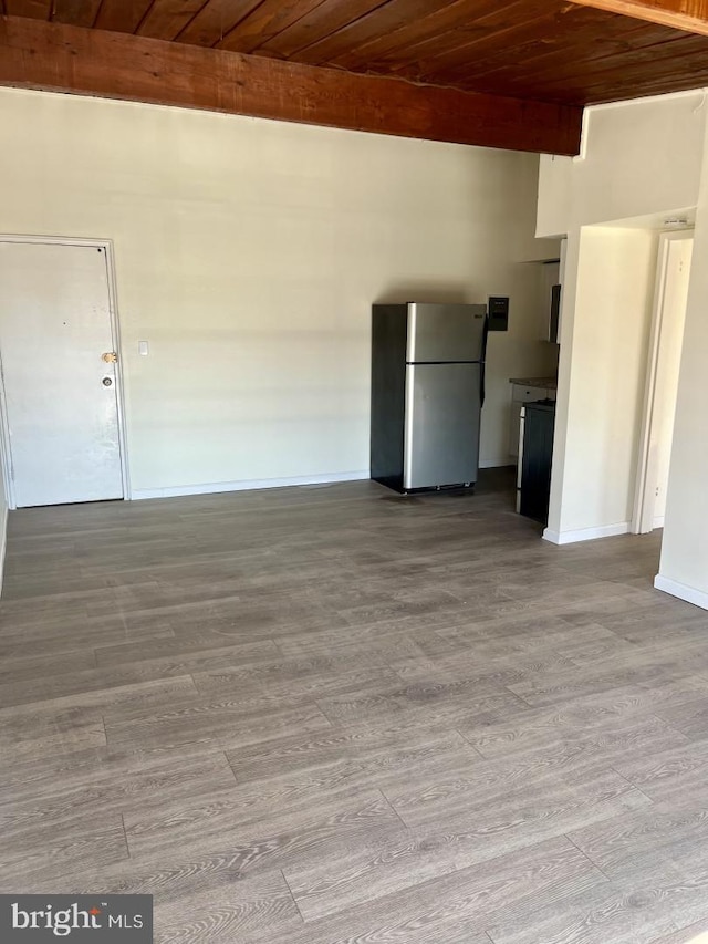 unfurnished living room featuring light wood finished floors, beamed ceiling, wooden ceiling, and baseboards