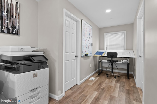 office space with visible vents, baseboards, and wood finished floors