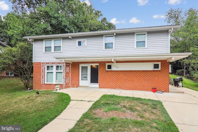 view of front of home featuring brick siding and a front lawn