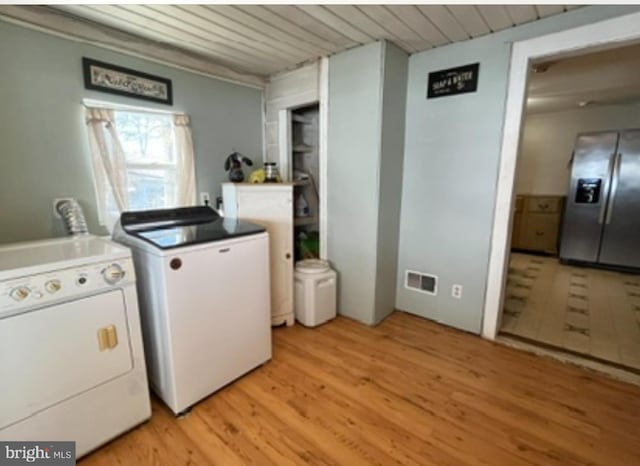 clothes washing area featuring laundry area, visible vents, wood ceiling, light wood-type flooring, and washer and clothes dryer