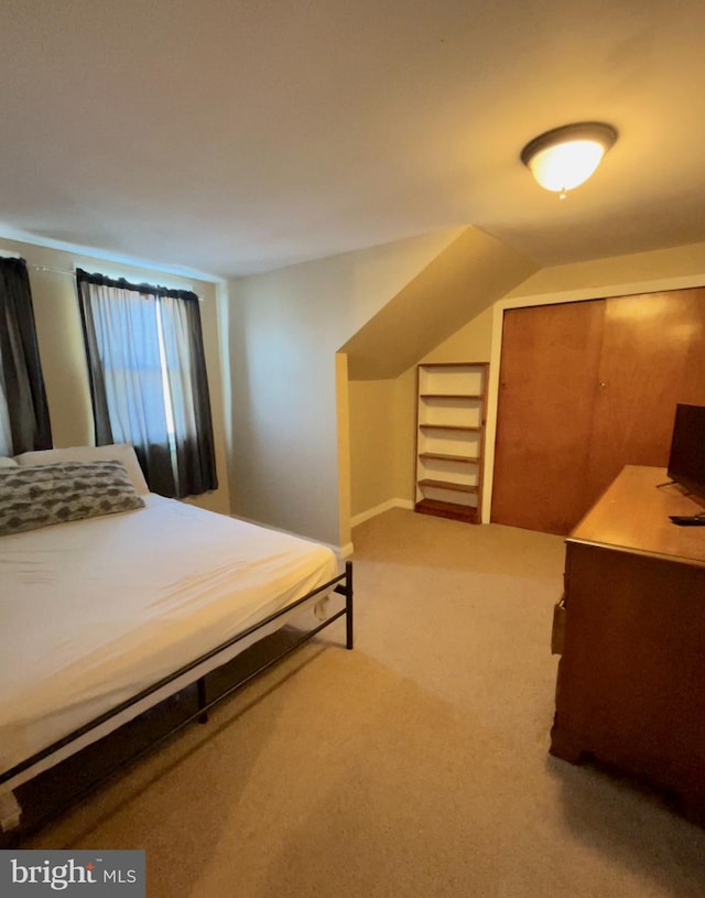 bedroom with carpet floors and lofted ceiling