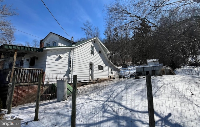 snow covered property with fence