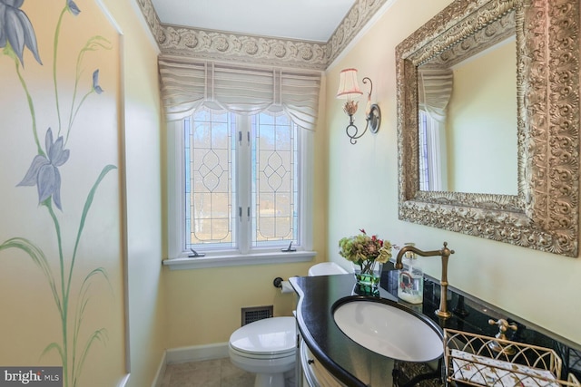 bathroom with baseboards, visible vents, vanity, and toilet