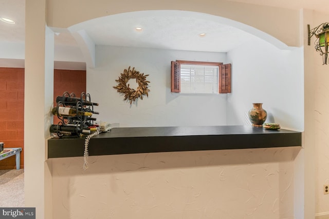 interior space with a dry bar, arched walkways, and recessed lighting