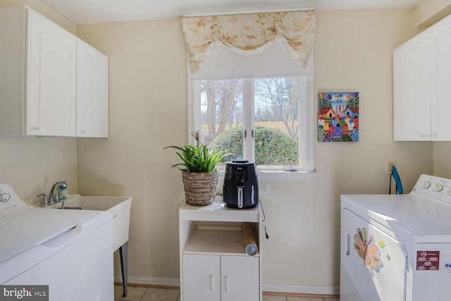 laundry area featuring cabinet space, light tile patterned floors, baseboards, and washer and clothes dryer