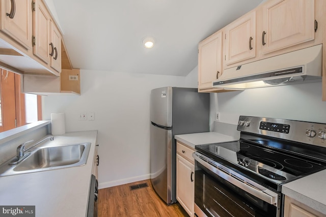 kitchen featuring stainless steel appliances, visible vents, light brown cabinets, a sink, and under cabinet range hood