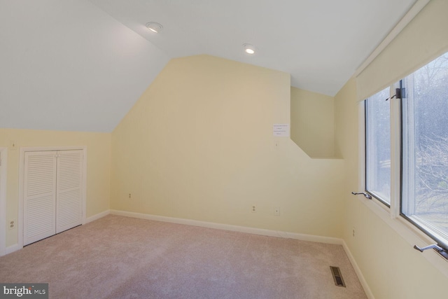 additional living space with lofted ceiling, carpet floors, visible vents, and baseboards