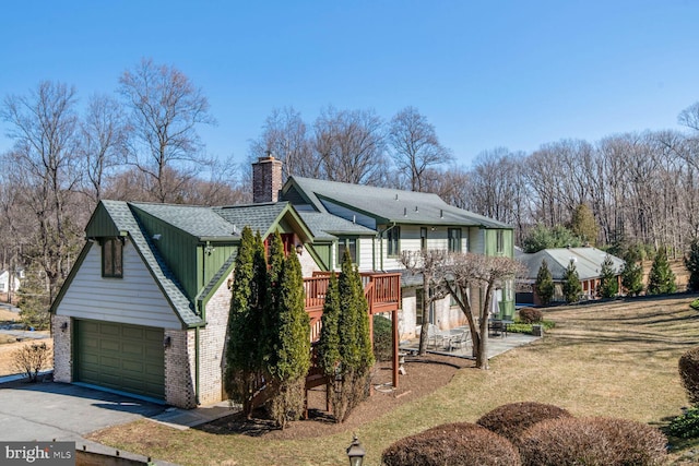 view of front of property featuring roof with shingles, brick siding, a chimney, board and batten siding, and a garage