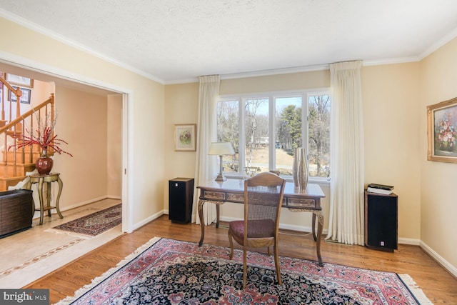 home office with a textured ceiling, baseboards, wood finished floors, and ornamental molding