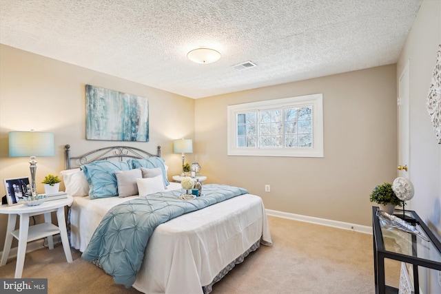 bedroom with baseboards, visible vents, a textured ceiling, and light colored carpet