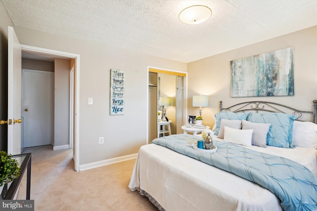 bedroom featuring light carpet, a closet, a textured ceiling, and baseboards