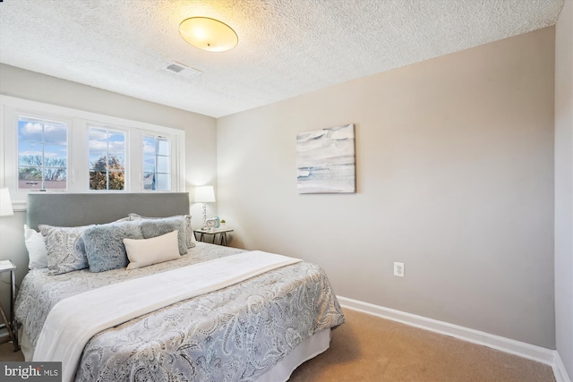 carpeted bedroom with a textured ceiling and baseboards