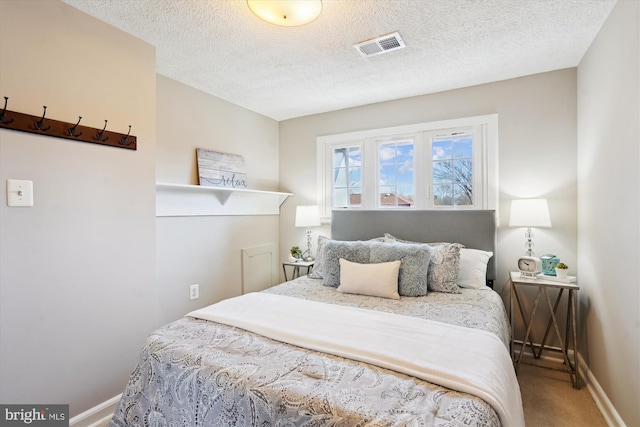 bedroom featuring carpet floors, baseboards, visible vents, and a textured ceiling