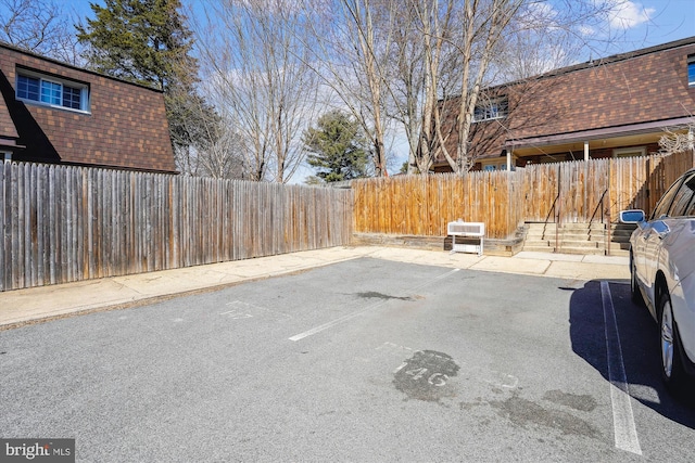 uncovered parking lot with a fenced backyard