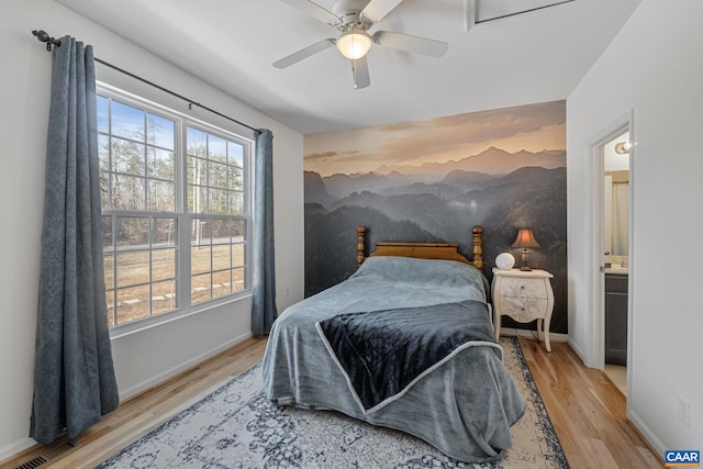 bedroom featuring baseboards, visible vents, and wood finished floors